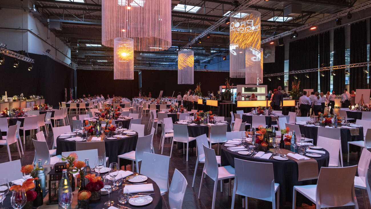 Abendveranstaltung der InterTabac in der abgeteilten Halle 3 – mit festlicher Galabestuhlung und großen Deckenleuchten